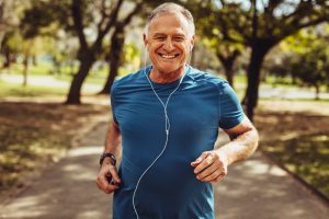man smiling while listening to music and jogging outside